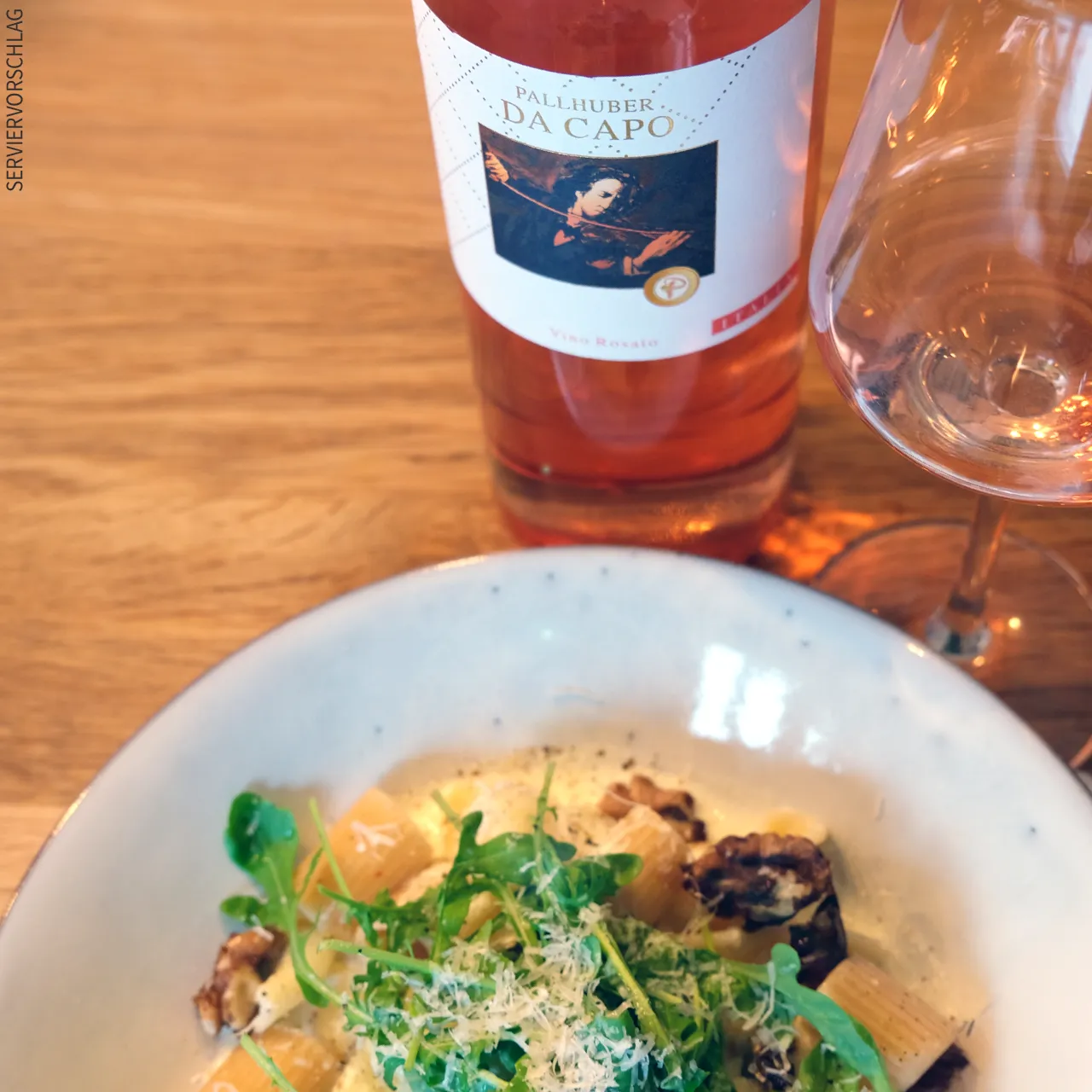 Genießen Sie den Pallhuber Da Capo rosato als Solist oder kombinieren Sie Ihn als harmonischen Speisebegleiter Ein Teller mit Pasta, eine Flasche Pallhuber Da Capo rosato und ein Glas mit dem Wein gefüllt