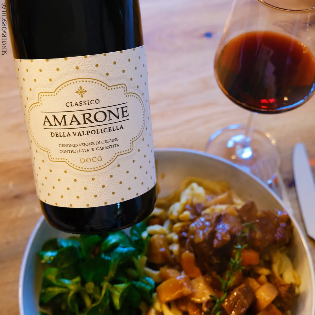 Amarone - Toller Solist und hervorragende Speisebegleitung Flasche Amarone, Glas mit Inhalt und dazu deftiges Essen mit Salat