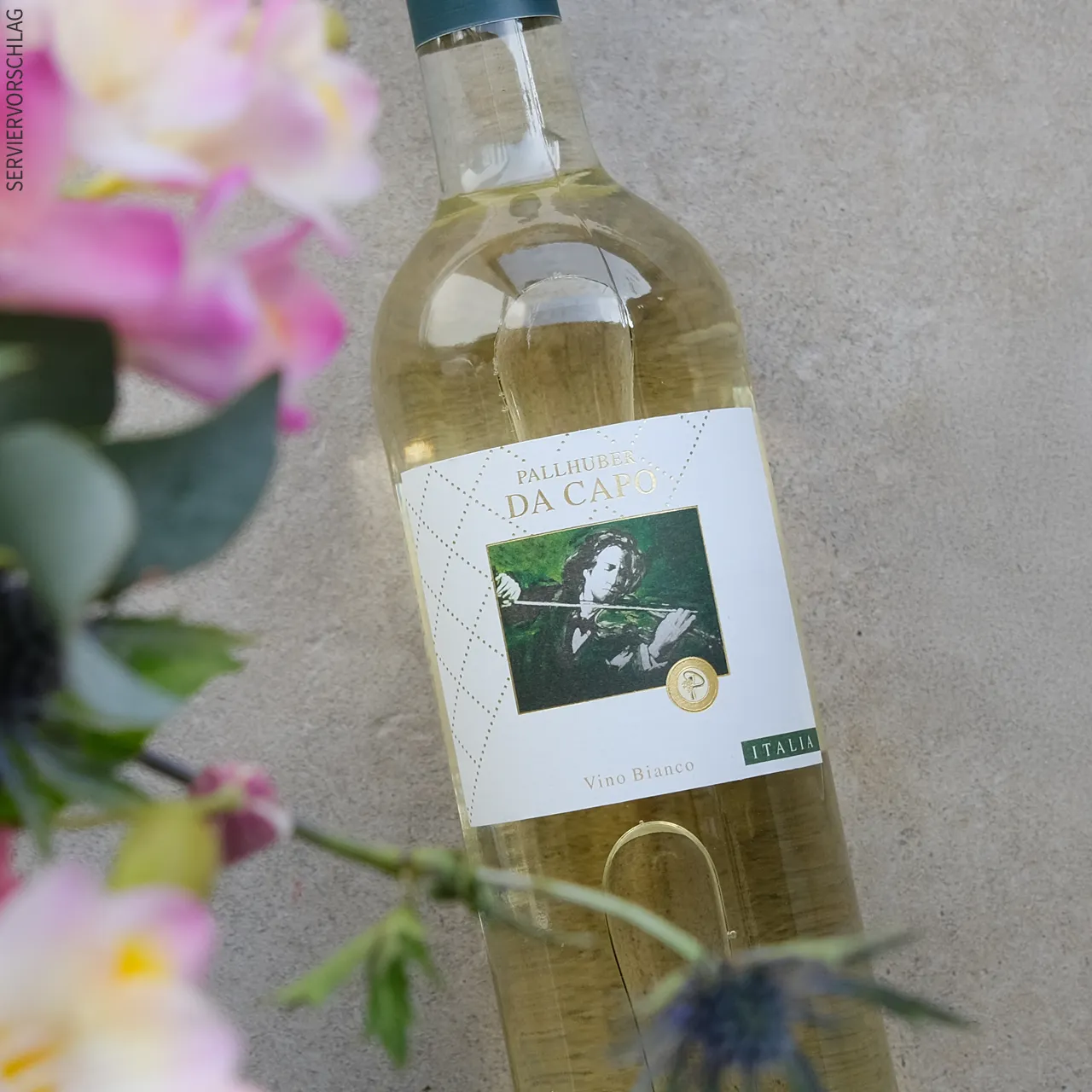 Weißweingenuss aus Italien, den wir lieben Ein Glas Weißwein, eine Flasche Pallhuber Da Capo Bianco und Blumen