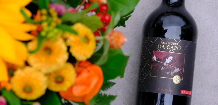 Entdecken Sie unsere hervorragende Weinauswahl Flasche Wein und Blumen