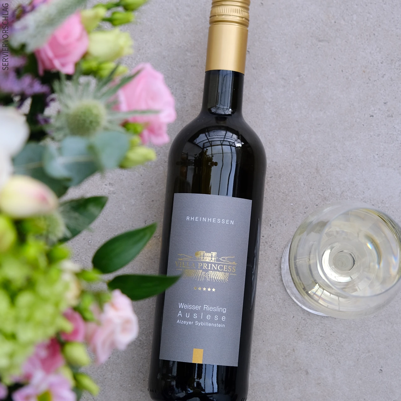 Blumen, eine Flasche Weisser Riesling Auslese und ein Glas Weißwein