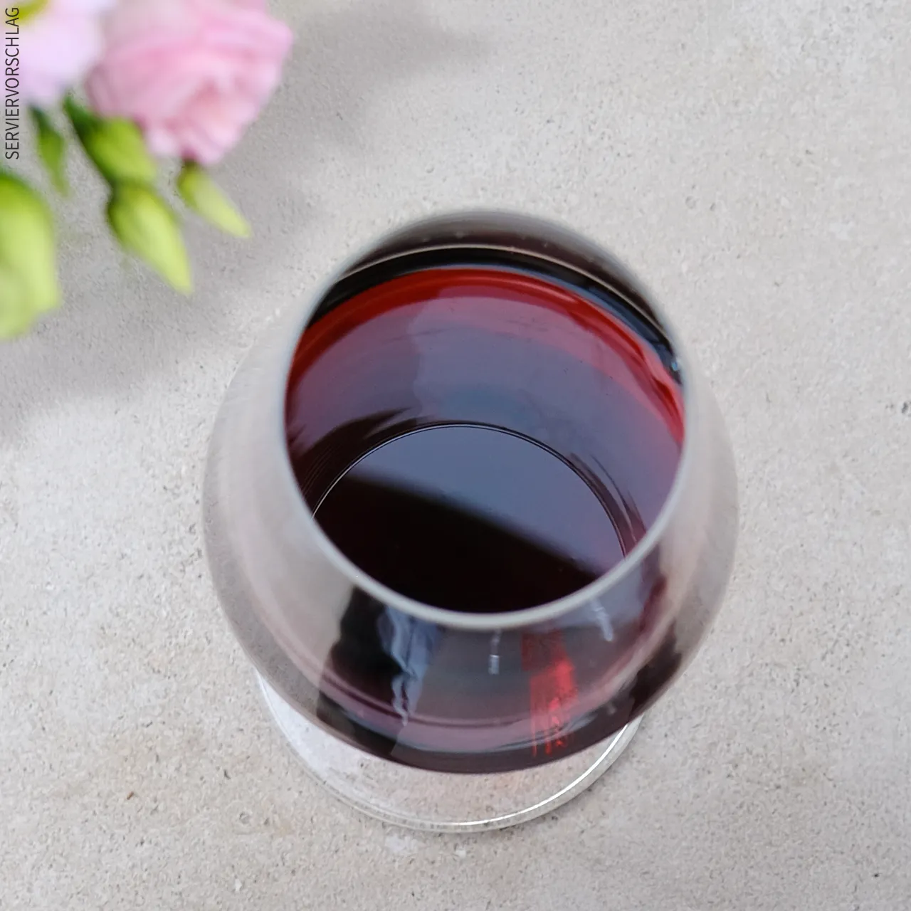 Leuchtend starke Farbe und überwältigender Geschmack Blumen und ein Glas Rotwein